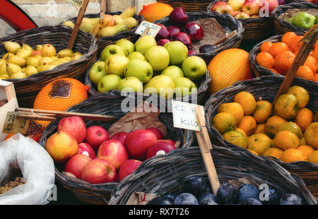 Market vendor cart with varied fruit in wicker baskets Stock Photo