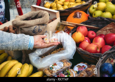 Market vendor cart with varied fruit in wicker baskets and sacks Stock Photo