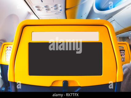 Back of a passenger seat on a commercial airline plane with empty area for advertising copy space Stock Photo