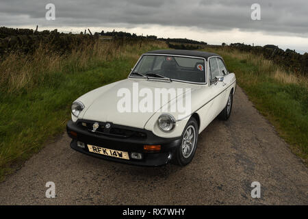 MGB GT British classic car standing on a country lane in the Peak District Derbyshire, UK Stock Photo