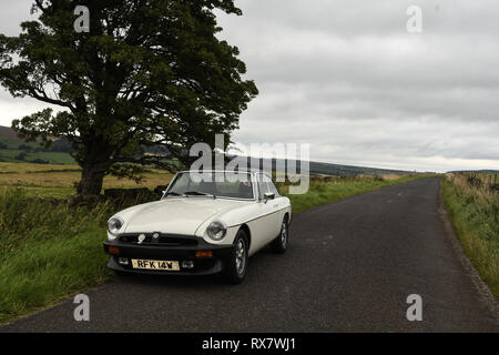MGB GT British classic car standing on a country lane in the Peak District Derbyshire, UK Stock Photo