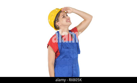 Medium shot. Side view. Engineer construction worker woman looking up at something amazing and laughing on white background. Professional shot in 4K r Stock Photo