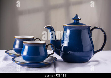 Old-fashioned teapot and matching cups and saucers Stock Photo