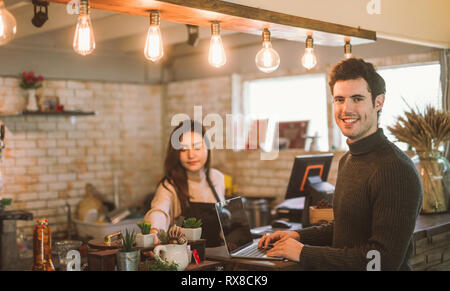 business owner using laptop working with laptop at the bar of the modern cafe Stock Photo