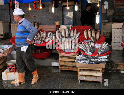 Istanbul, Turkey - February 15, 2019: Fisherman in Istanbul selling the catch of the day on a fish market while smoking a cigarette Stock Photo