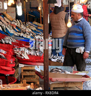 Istanbul, Turkey - February 15, 2019: Fisherman in Istanbul selling the catch of the day on a fish market while smoking a cigarette Stock Photo