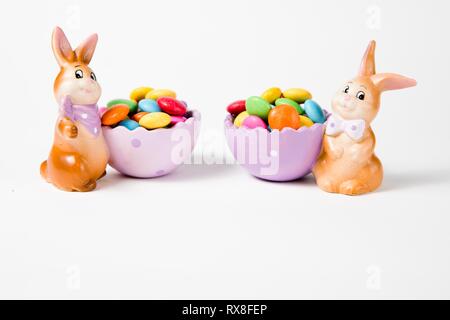 Easter decorations - Bunnies with baskets full of chocolate - sweets. Stock Photo