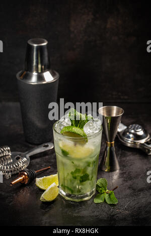 Mojito cocktail with drink making tools on black background Stock Photo