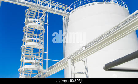 The tank with water and a ladder. Oil refinery. Equipment for primary oil refining. Stock Photo
