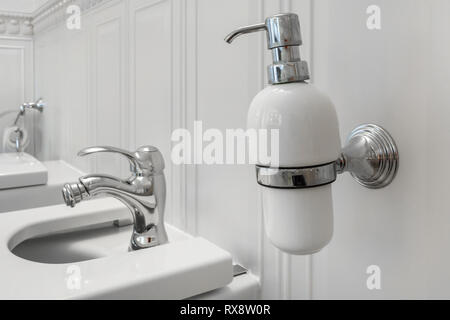 toilet and detail of a corner shower bidet with soap and shampoo dispensers on wall mount shower attachment Stock Photo