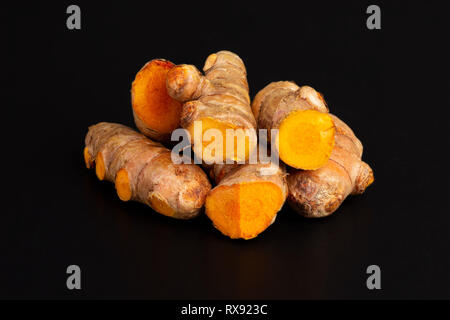 Heap of curcuma turmeric spice roots on dark black background Stock Photo