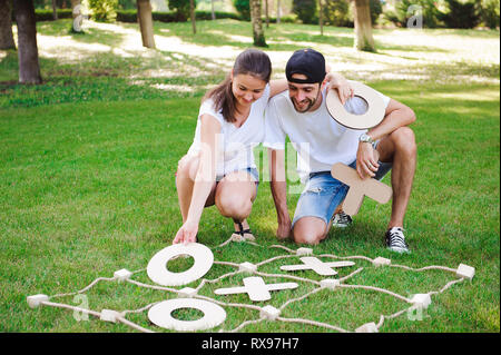 Laughing boy and girl playing tic-tac-toe in the park Stock Photo