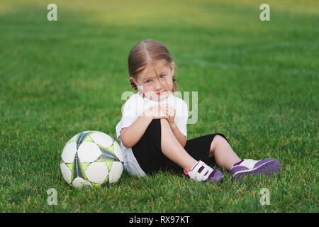 little happy girl on football field Stock Photo