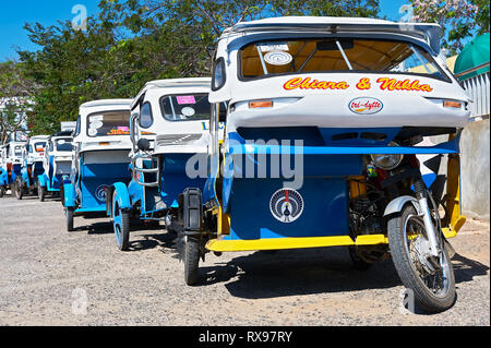 Puerto Princesa City, Palawan, Philippines: Blue and white tricycles waiting in line for tourists in front of the airport Stock Photo