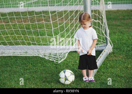 little happy girl on football field Stock Photo