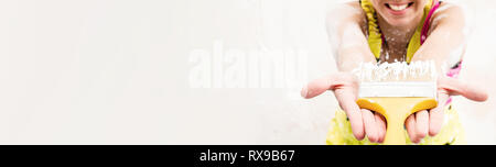 Cropped image female wearing coverall protective work wear holding paint brush, showing to the camera and smiling selective focus copy space Stock Photo