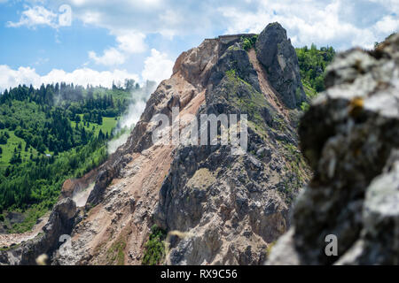 Explosion in a limestone quarry owned by HeidelbergCement, near Bicaz Gorge, Neamt county, Romania, as seen from an adjacent mountain top, on a sunny  Stock Photo