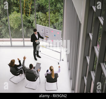businessman having business meeting with his staff. showing presentation on flip chart. Stock Photo