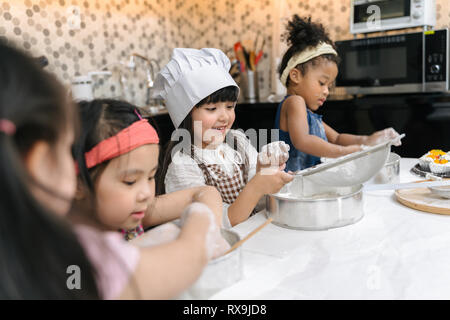 Group of kids are preparing the bakery in the kitchen .Children learning to cooking cookies Stock Photo