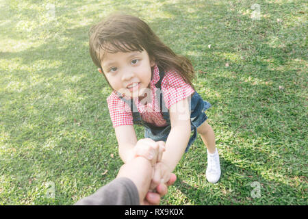 little cute girl holding hands parents looking at camera Stock Photo