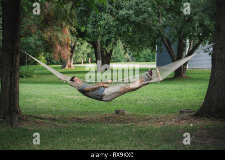 Full length of man lying in hammock at park Stock Photo