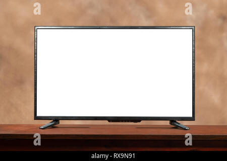 Horizontal shot of a blank large screen tv with copy space on table.  Brown muddled background. Stock Photo