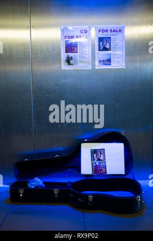 A buskers guitar case lies open in blue neon light in an underpass lochaber fort william scottish highlands uk Stock Photo