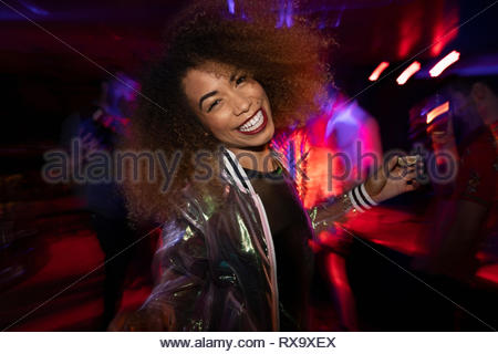 Portrait carefree young woman dancing in nightclub