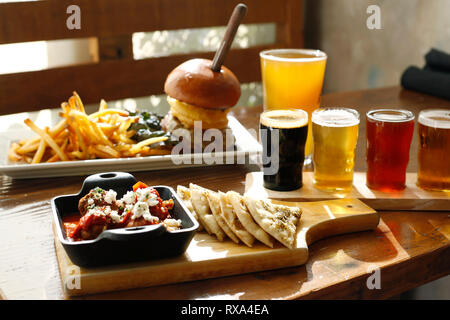 High angle view of fast food with beer served on wooden table in restaurant Stock Photo
