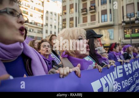 Protesters are shouting slogans while holding a banner during the demonstration. Spanish people celebrate International Women's Day with a women's general strike against gender violence. Stock Photo