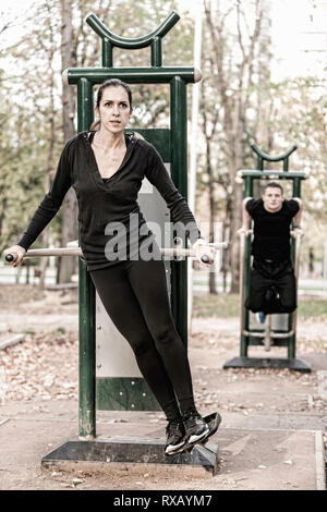 Couple exercising in public outdoor gym Stock Photo