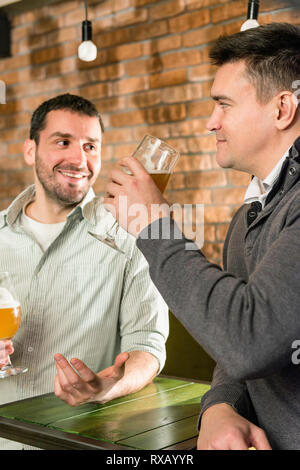 Friends drinking beer in a pub Stock Photo