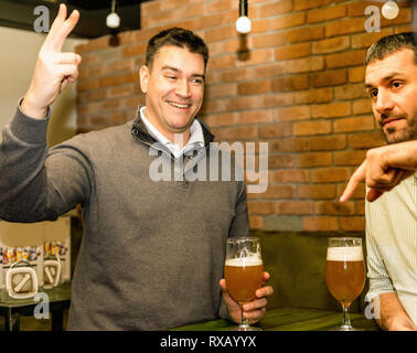 Friends drinking beer in a pub Stock Photo