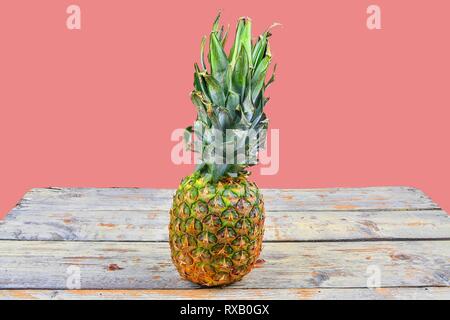 Fresh pineapple isolated against a pink background Pineapple on white wooden backgroud. Copy space. Stock Photo