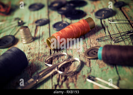 High angle close-up of various sewing items on old wooden table Stock Photo