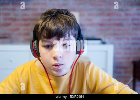 Close-up of boy using headphones while studying at home Stock Photo