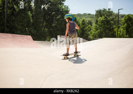 Full length of boy skateboarding in park during sunny day Stock Photo