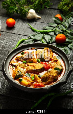 Seafood  dish from Asian cuisine , spicy fish curry cooked and served in earthen clay pottery, organic cooking concepts. Stock Photo