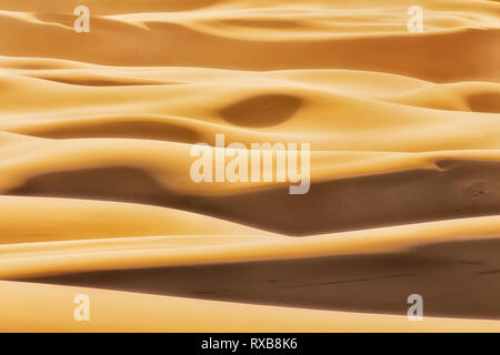 Simple shapes formed by sun light and shades on endless waves of sand dunes in arid lifeless desert of Australian Pacific coast at Stockton beach. Stock Photo