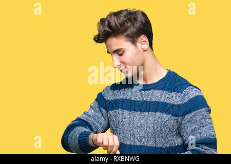 Young handsome man over isolated background Checking the time on wrist watch, relaxed and confident Stock Photo