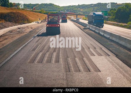 Tracks left by tire roller compactors when compacting asphalt. Stock Photo