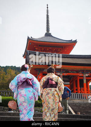 A group of female tourists wearing the traditional Japanese kimono dress walk up to the historic temple of the Kiyomizu-dera temple district at Kyoto.