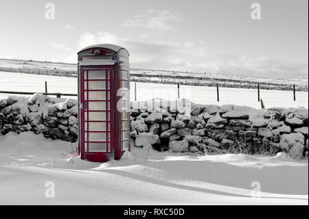 Traditional red BT telephone box in a rural location on a wintry, snowy day Stock Photo