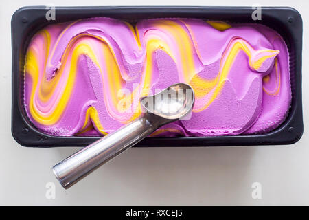 Multicolored pink, blue and purple gum flavor ice cream in metallic form with a special ice cream spoon Stock Photo