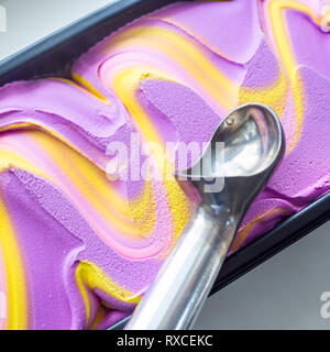 Multicolored pink, blue and purple gum flavor ice cream in metallic form with a special ice cream spoon Stock Photo