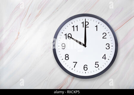 Wall clock show ten o'clock on marble texture. Office clock show 10pm or 10am Stock Photo