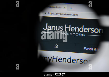 The Janus Henderson website is seen through a magnifying glass.  Janus Henderson formed in 2017 when Janus Capital Group and Henderson Global Investor Stock Photo