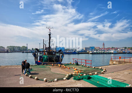 Poland, Wladyslawowo, fishing boat and fisherman preparing fish nets in port on Baltic Sea Stock Photo