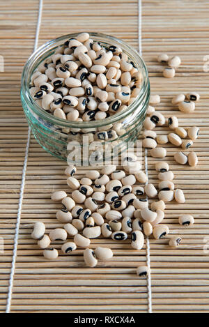 Black Eyed Beans spilling out of glass jar Stock Photo