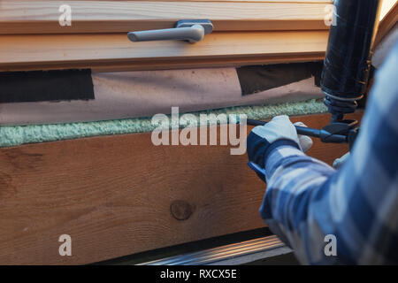 Foam window insulation on wooden construction. Building an eco-house. Heat insulation Stock Photo